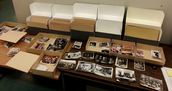 Dozens of photos from the Sarnoff collection laid out on a table for processing