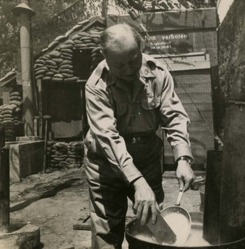 Sarnoff washing his dishes outside