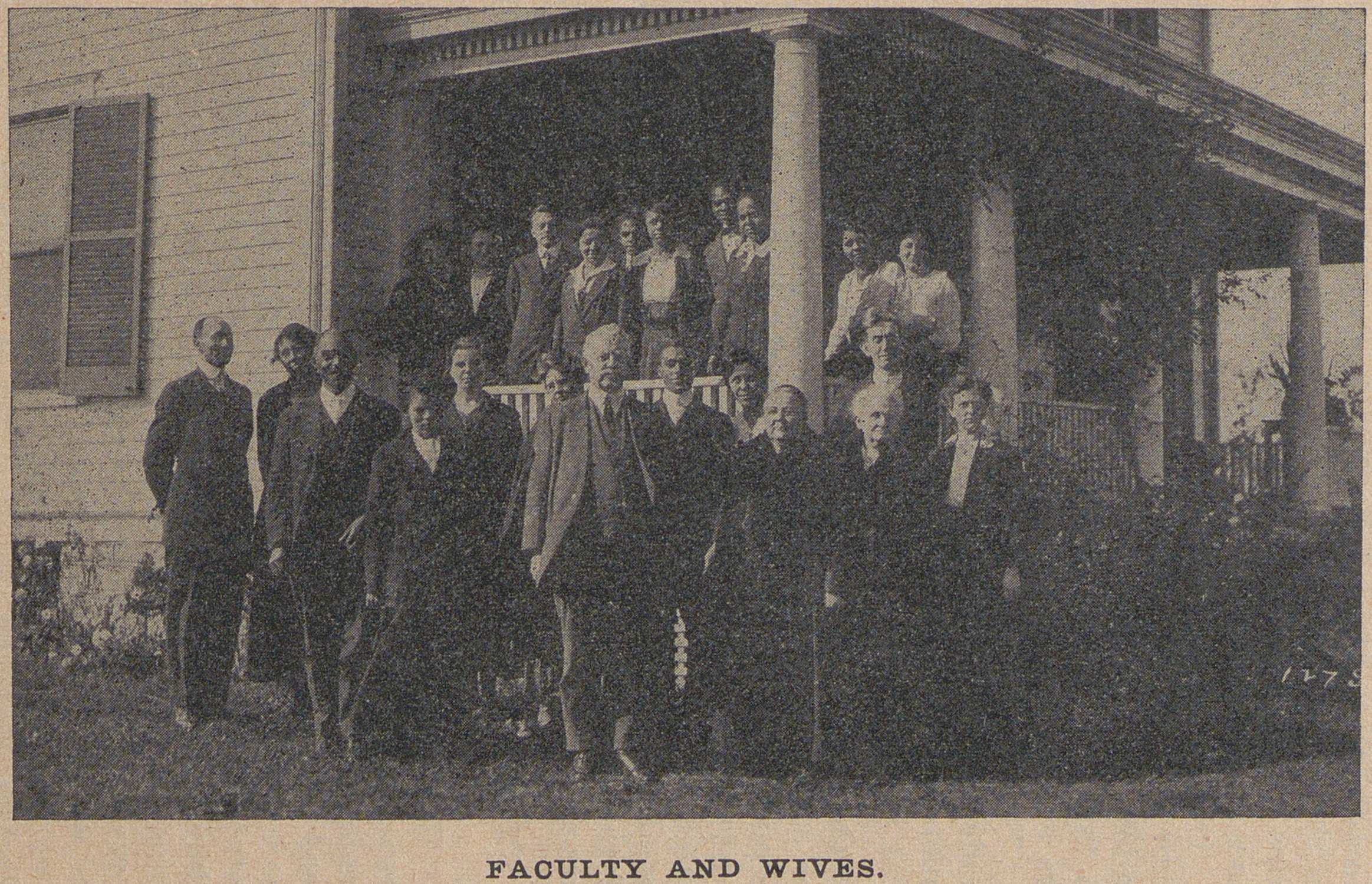 Black and white photograph of an interracial group of educators and their spouses on a porch.