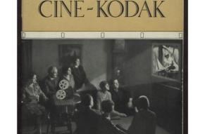 Cover of a catalog advertising Ciné-Kodak cameras, featuring a group of people in a home, gathered around a projector, watching a home movie.